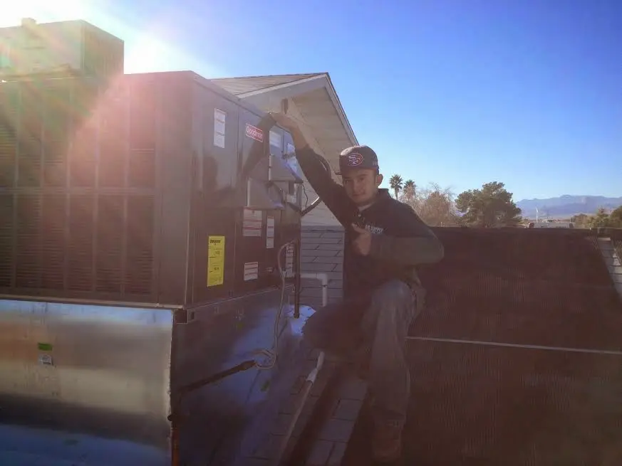 HVAC technician performing AC Tune-Up on a rooftop unit in Swissvale